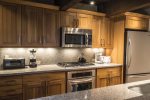 Fully equipped kitchen has stainless steel appliances and granite counters